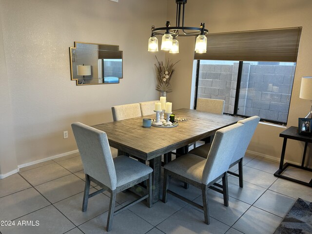 tiled dining room with a chandelier