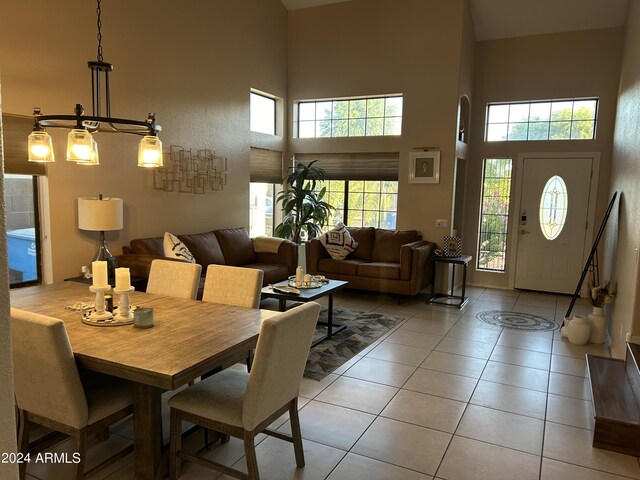 tiled dining area featuring a high ceiling and an inviting chandelier