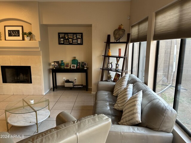 living room with a tiled fireplace and light tile patterned floors