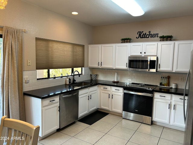 kitchen with backsplash, stainless steel appliances, white cabinetry, and sink