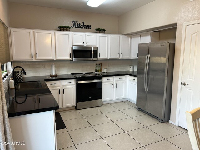 kitchen featuring appliances with stainless steel finishes, white cabinetry, and tasteful backsplash