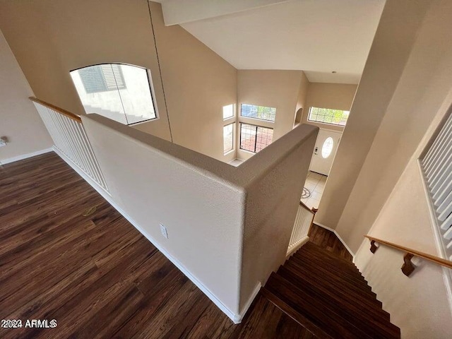 stairs with high vaulted ceiling and wood-type flooring