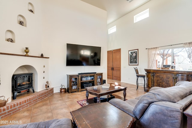 living room featuring a wood stove, light tile patterned floors, and a wealth of natural light