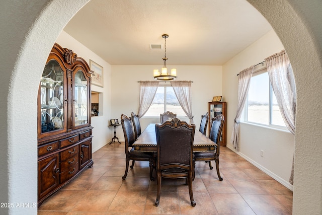 dining room featuring arched walkways, visible vents, a chandelier, and a healthy amount of sunlight