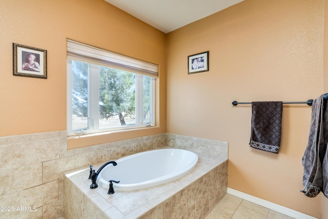 bathroom featuring tile patterned flooring, baseboards, and a garden tub