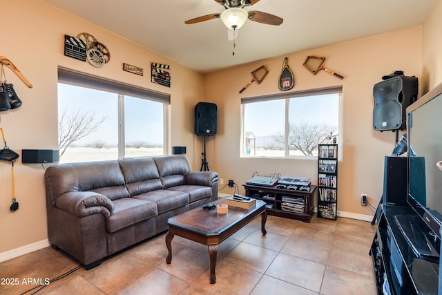 living area featuring tile patterned floors, baseboards, and a ceiling fan