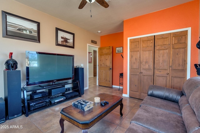 living area with tile patterned floors, baseboards, and a ceiling fan