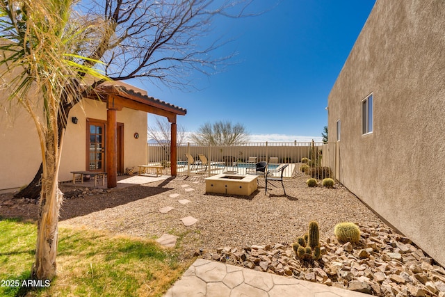 view of yard with a fire pit, a fenced backyard, and a patio area