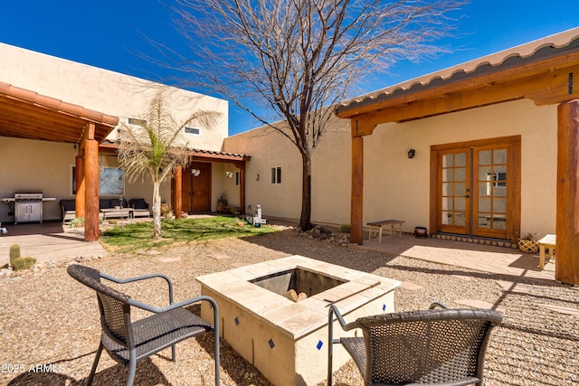 view of patio / terrace with a grill, french doors, and an outdoor fire pit