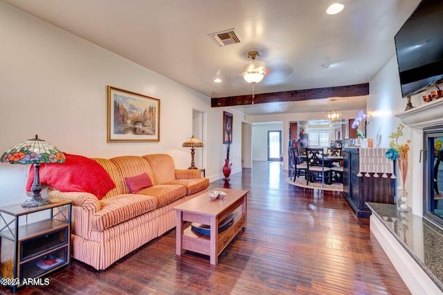 living room with dark hardwood / wood-style flooring and ceiling fan with notable chandelier