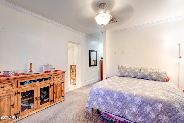 carpeted bedroom featuring ceiling fan and crown molding