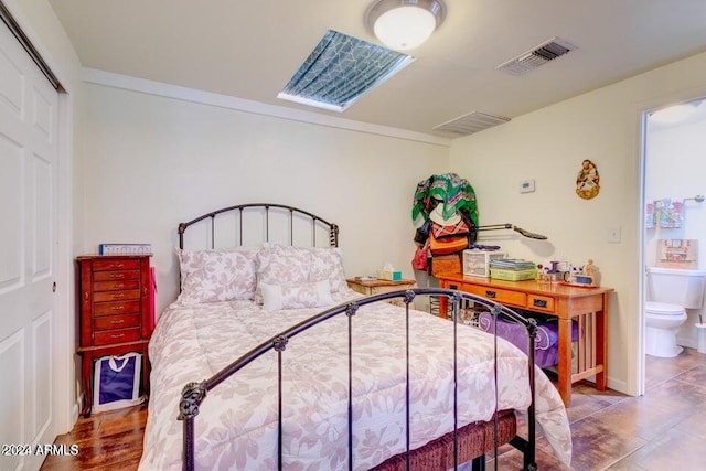 bedroom with a closet, tile patterned flooring, and ensuite bathroom