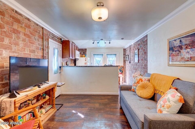 living room featuring rail lighting, crown molding, and brick wall