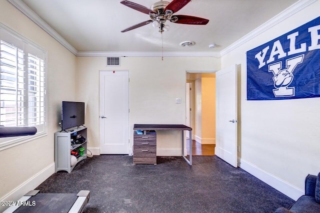 unfurnished office with ceiling fan, crown molding, and dark carpet