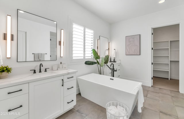 bathroom featuring a bathing tub, tile patterned flooring, and vanity