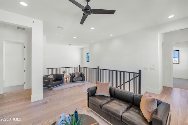 living room featuring light wood-type flooring and ceiling fan