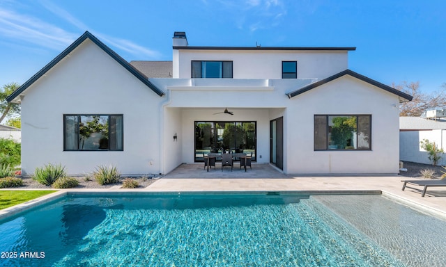 back of property featuring ceiling fan and a patio