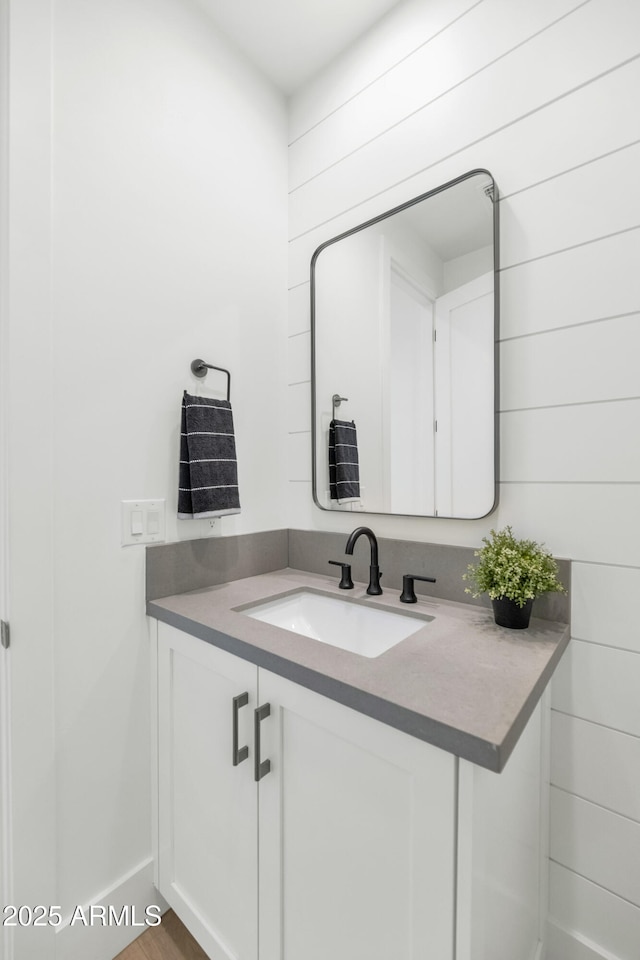 bathroom featuring vanity and wood walls