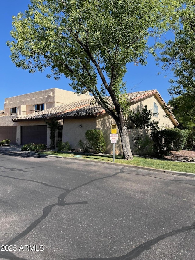 6223 N 12th St Unit 1, Phoenix, AZ 85014 - view of front of home with stucco siding, a tiled roof, and a garage