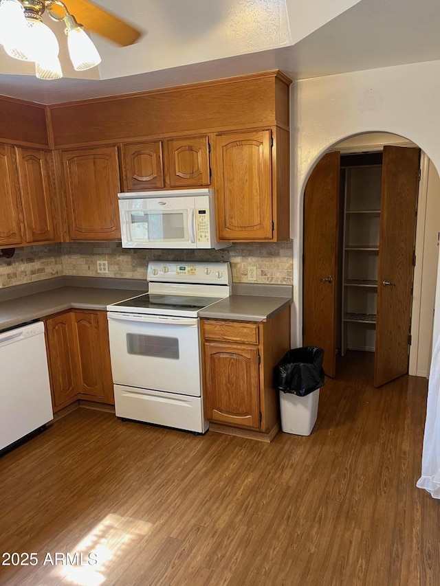 6223 N 12th St Unit 1, Phoenix, AZ 85014 - kitchen featuring white appliances, arched walkways, wood finished floors, and brown cabinets