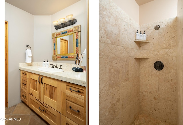 bathroom with vanity, tile patterned flooring, and a tile shower