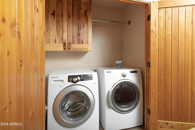 washroom with washing machine and dryer and cabinets