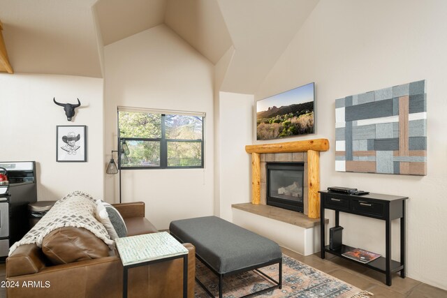 living room featuring high vaulted ceiling and a tile fireplace