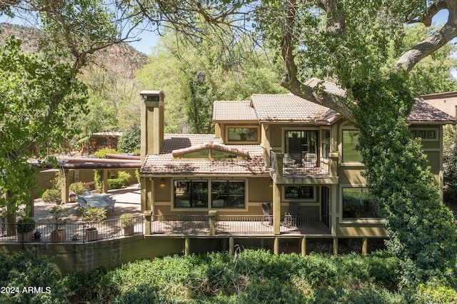 rear view of property featuring a balcony and a patio area