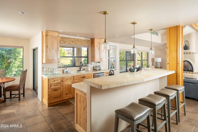 kitchen with a breakfast bar area, hanging light fixtures, and sink