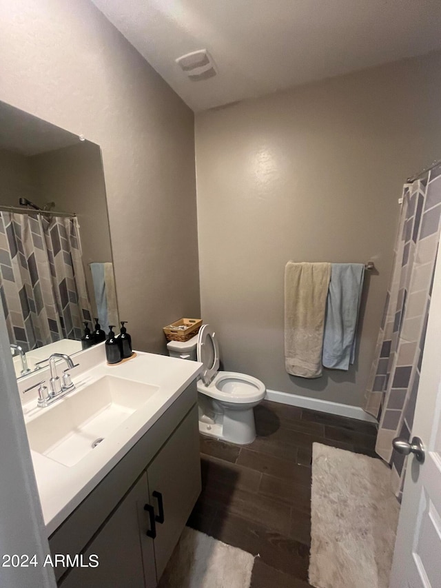 bathroom featuring vanity, toilet, a shower with shower curtain, and hardwood / wood-style floors