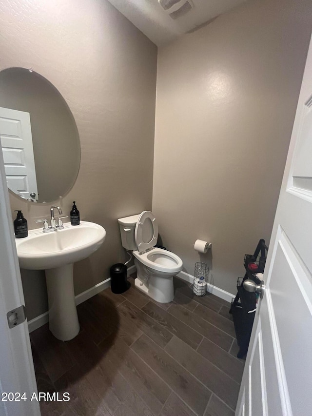 bathroom featuring toilet and wood-type flooring