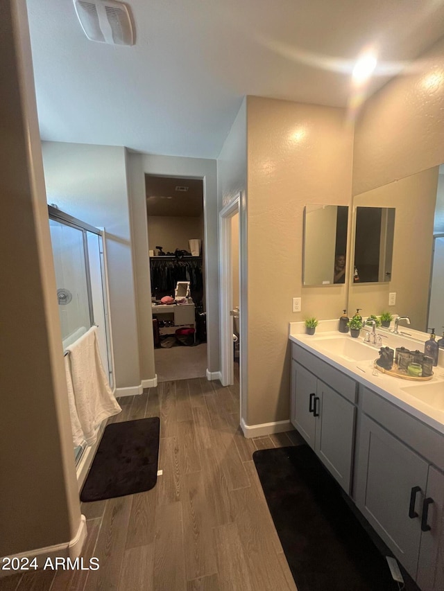 bathroom featuring vanity, hardwood / wood-style flooring, and walk in shower