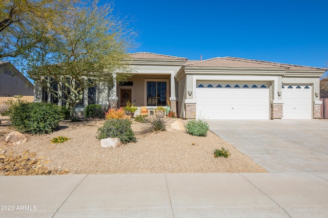 view of front of house with concrete driveway, a tiled roof, a garage, and stucco siding