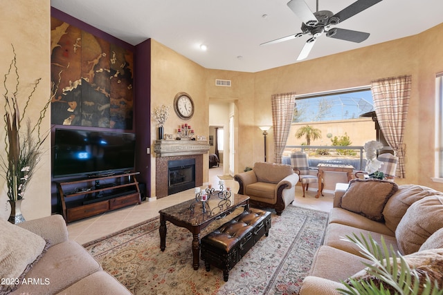 tiled living area featuring a fireplace, visible vents, and ceiling fan