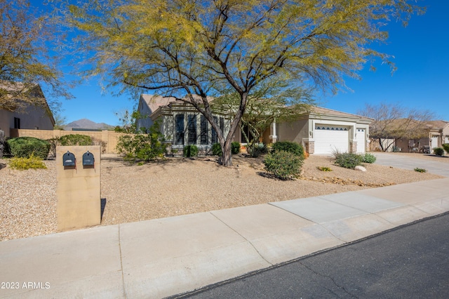 view of front of home featuring an attached garage, driveway, fence, and stucco siding