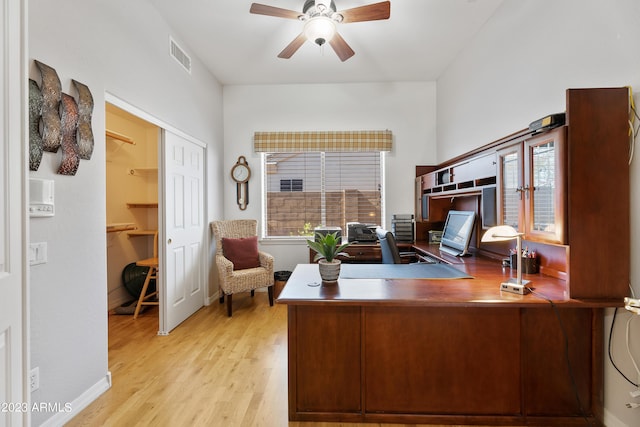 office space featuring visible vents, baseboards, a ceiling fan, and light wood finished floors