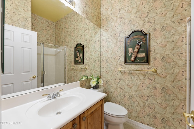 bathroom featuring a shower stall, wallpapered walls, vanity, and toilet