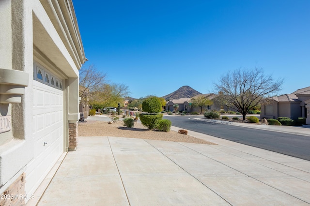 view of patio with a residential view, a mountain view, and a garage