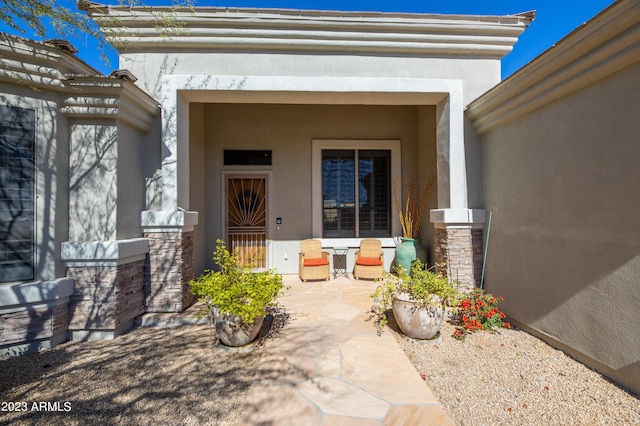 view of exterior entry with stone siding and stucco siding