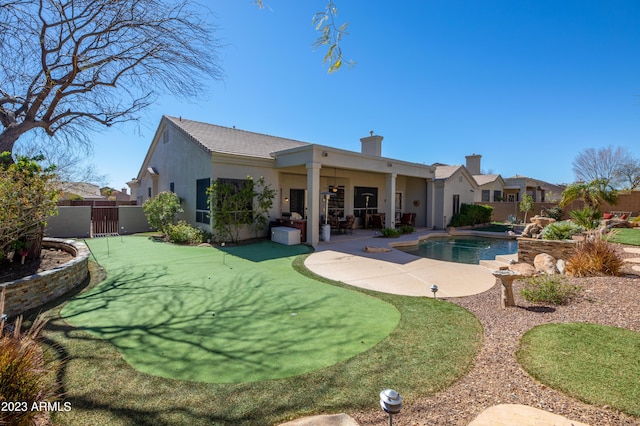 back of house featuring a fenced in pool, stucco siding, a chimney, a fenced backyard, and a patio area