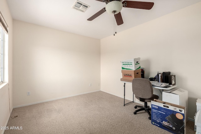 carpeted office with baseboards, visible vents, and a ceiling fan