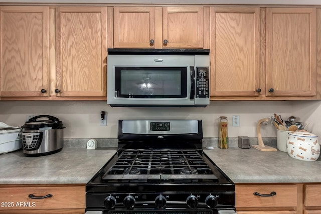 kitchen with range with gas cooktop and stainless steel microwave