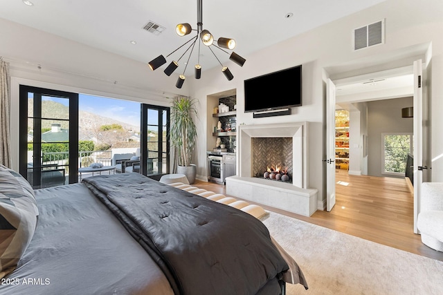 bedroom featuring access to exterior, beverage cooler, and light hardwood / wood-style flooring