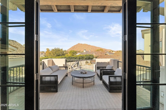 balcony featuring a mountain view and an outdoor hangout area