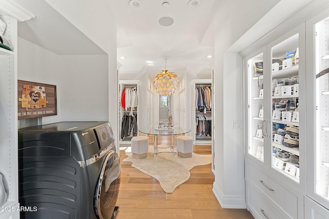 interior space with independent washer and dryer and light hardwood / wood-style floors