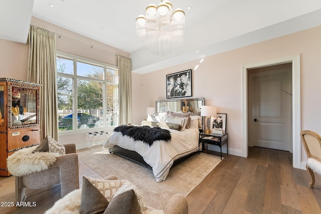 bedroom featuring an inviting chandelier and light wood-type flooring