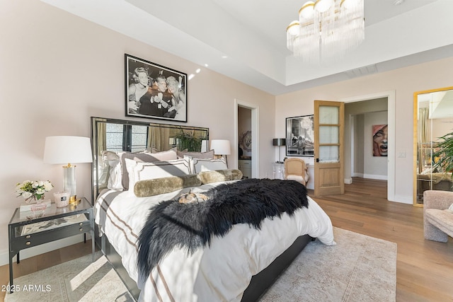 bedroom with a chandelier and light hardwood / wood-style floors