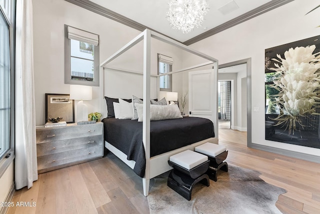 bedroom with an inviting chandelier, crown molding, and wood-type flooring