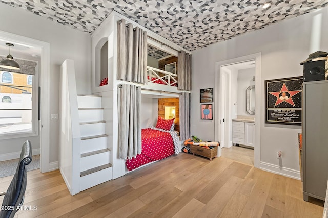 bedroom featuring light hardwood / wood-style flooring and ensuite bathroom