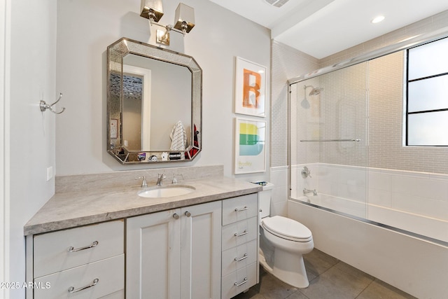 full bathroom with toilet, vanity, bath / shower combo with glass door, and tile patterned flooring